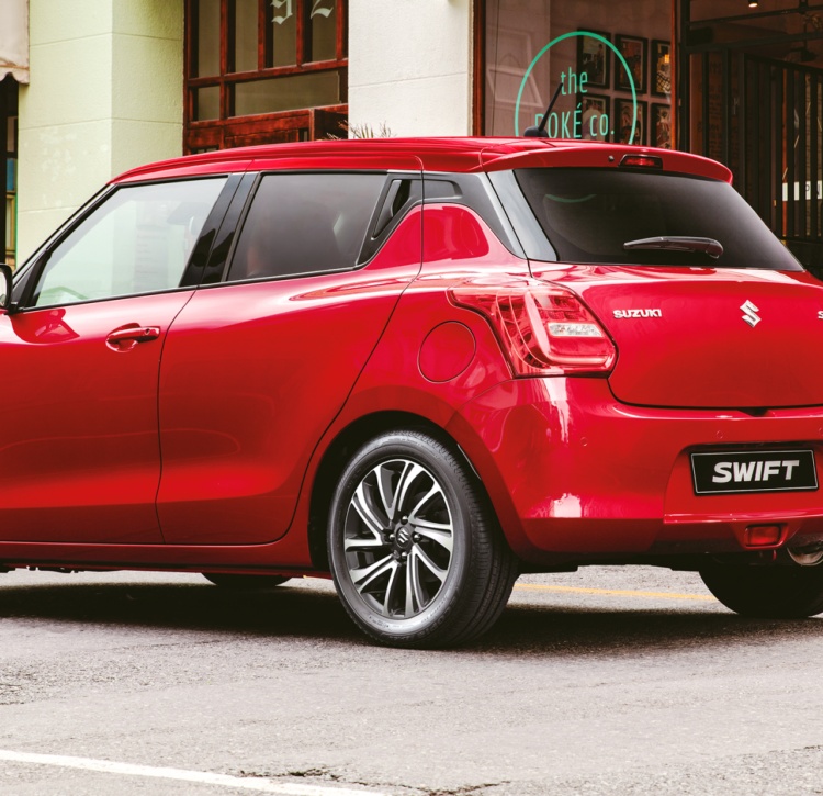 Hot red Suzuki Swift parked outside city cafe