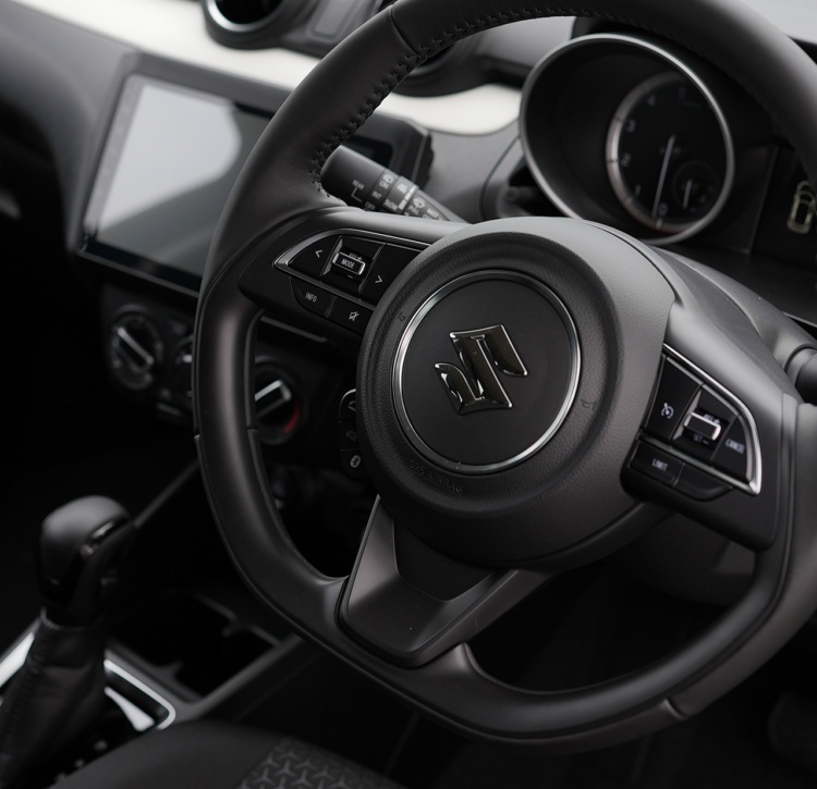 The sleek and functional interior of the Suzuki Swift with steering wheel controls